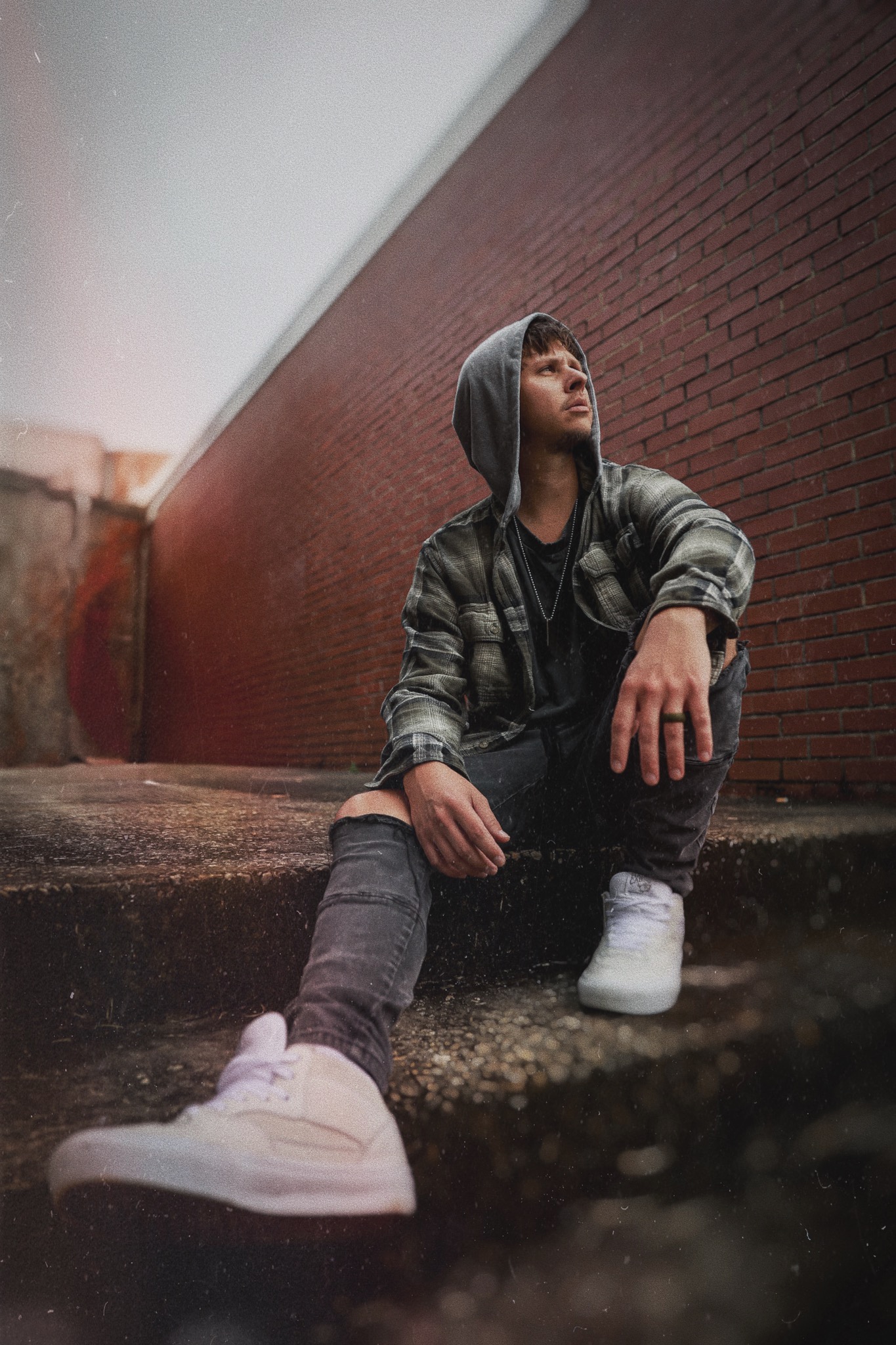 Will Watkins sitting beside a brick wall